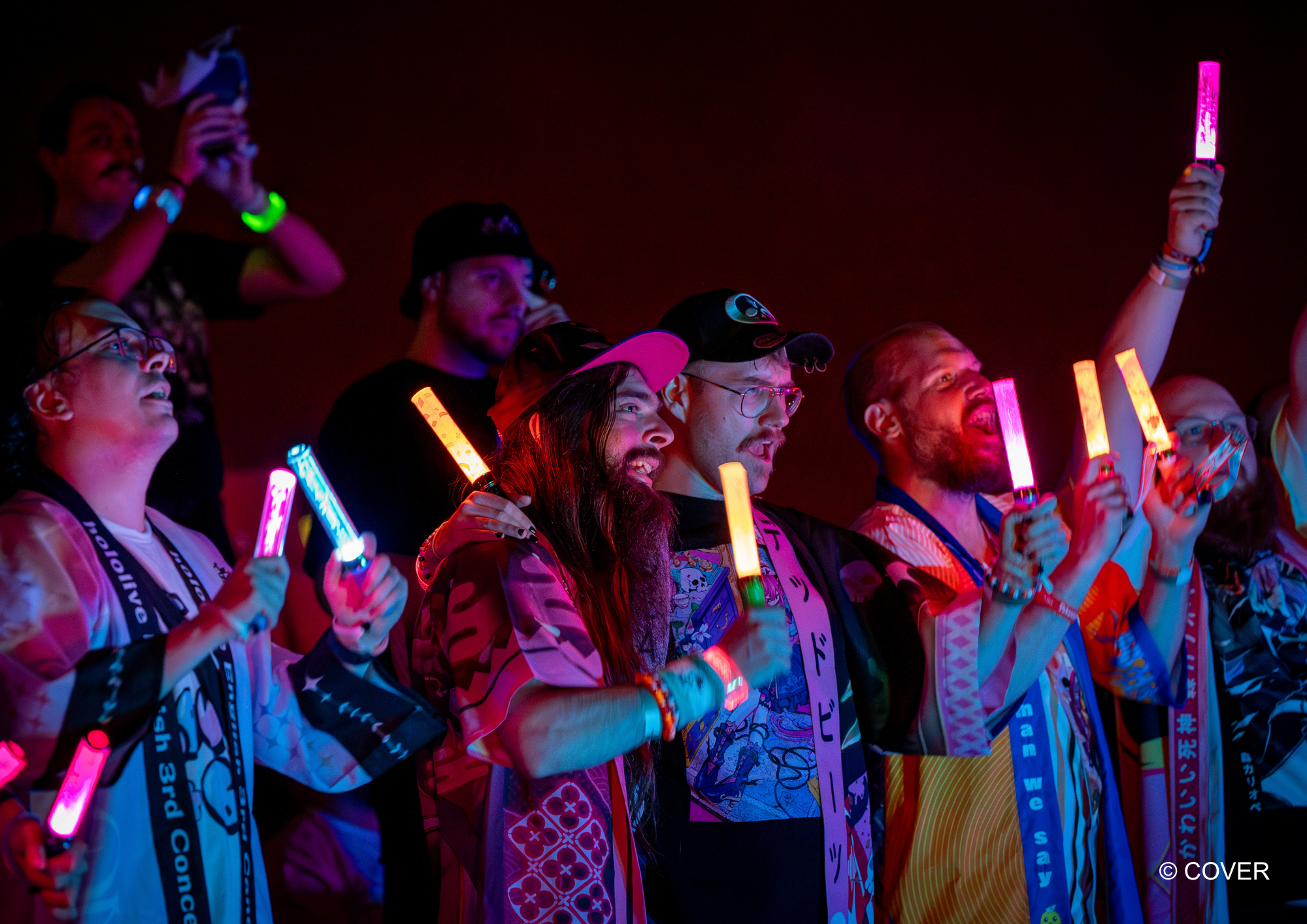 Fans wearing happi coats and holding colourful penlights at an earlier hololive concert screening in Berlin