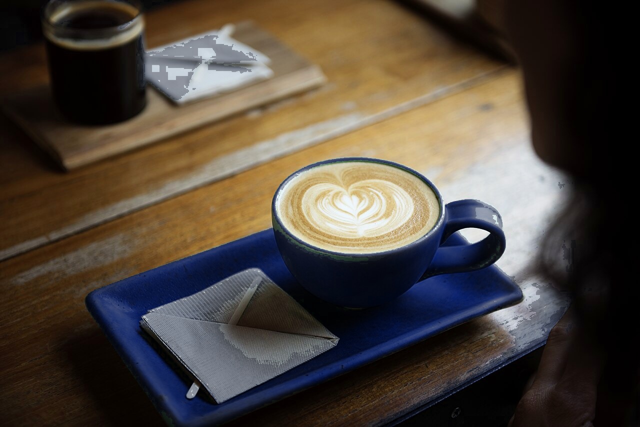 A latte in a blue cup on a café table